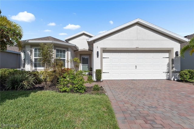 2245 Pigeon Plum Way N, Fort Myers, FL 33917 - ranch-style home featuring stucco siding, decorative driveway, a garage, and a front lawn