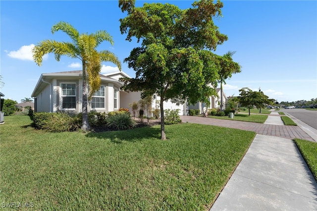 2245 Pigeon Plum Way N, Fort Myers, FL 33917 - obstructed view of property featuring decorative driveway, a front yard, and a garage