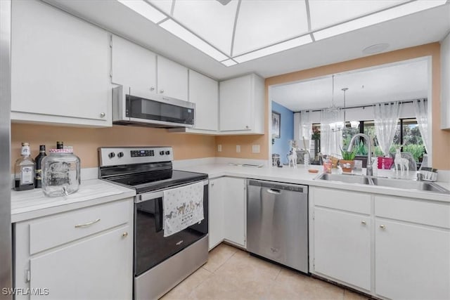 20013 Petrucka Cir N, Lehigh Acres, FL 33936 - kitchen with appliances with stainless steel finishes, white cabinetry, light countertops, and light tile patterned floors