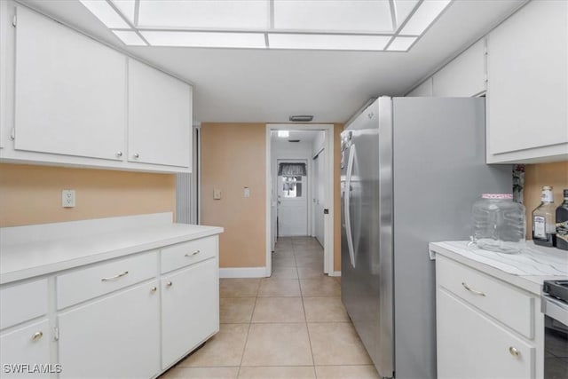 20013 Petrucka Cir N, Lehigh Acres, FL 33936 - kitchen featuring light countertops, white cabinets, freestanding refrigerator, and light tile patterned floors