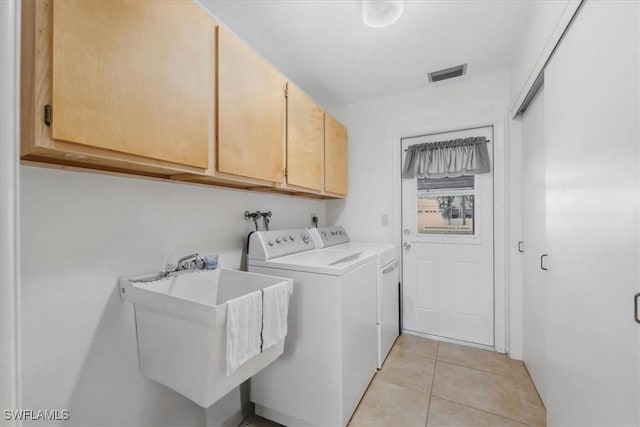 20013 Petrucka Cir N, Lehigh Acres, FL 33936 - laundry area featuring cabinet space, washer and clothes dryer, and light tile patterned floors