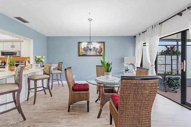20013 Petrucka Cir N, Lehigh Acres, FL 33936 - dining space featuring a chandelier and light wood-type flooring