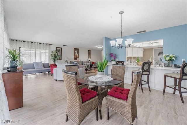 20013 Petrucka Cir N, Lehigh Acres, FL 33936 - dining room featuring a chandelier and light wood-style floors