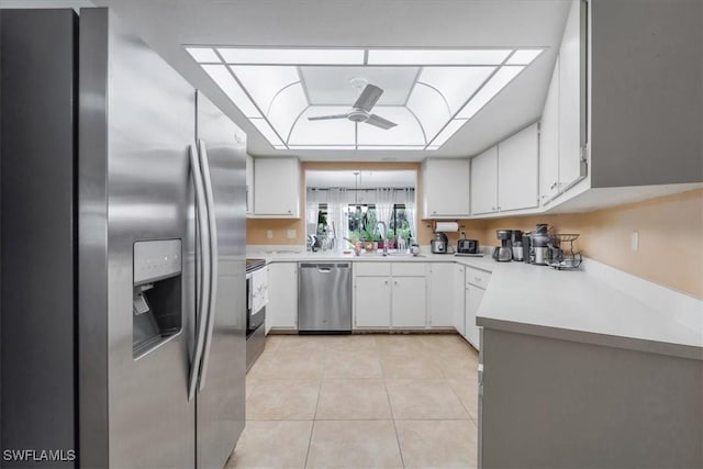 20013 Petrucka Cir N, Lehigh Acres, FL 33936 - kitchen featuring stainless steel appliances, a ceiling fan, light countertops, light tile patterned floors, and white cabinetry