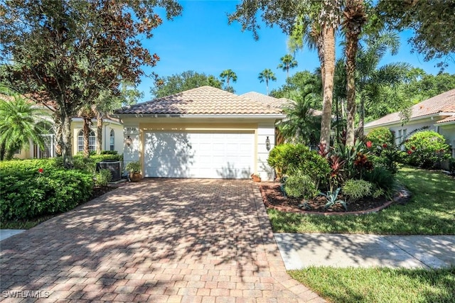 2799 Jude Island Way, Naples, FL 34119 - view of front facade featuring an attached garage, a tiled roof, and decorative driveway