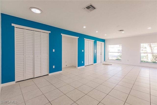 217 Yorkshire Ct Unit 2, Naples, FL 34112 - unfurnished bedroom with multiple closets, recessed lighting, and light tile patterned floors