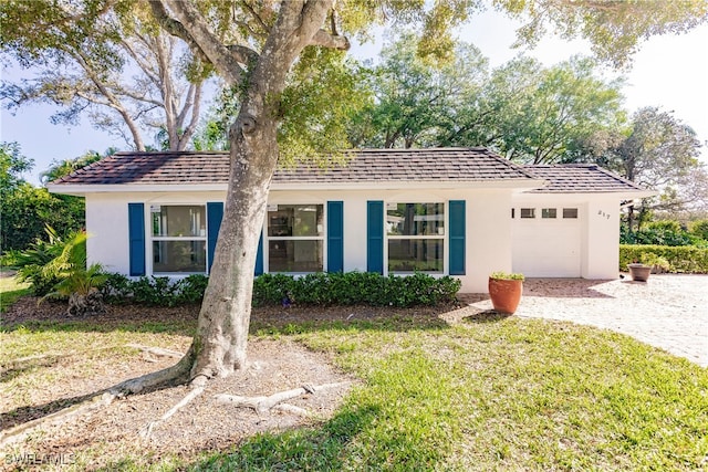 217 Yorkshire Ct Unit 2, Naples, FL 34112 - ranch-style house featuring stucco siding, an attached garage, a front lawn, and driveway