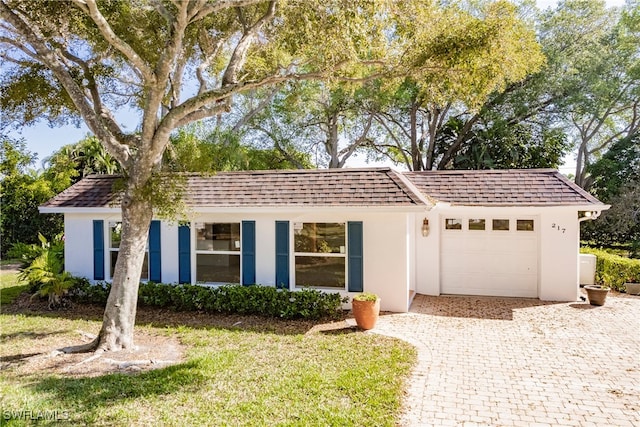 217 Yorkshire Ct Unit 2, Naples, FL 34112 - single story home with an attached garage, stucco siding, driveway, and roof with shingles