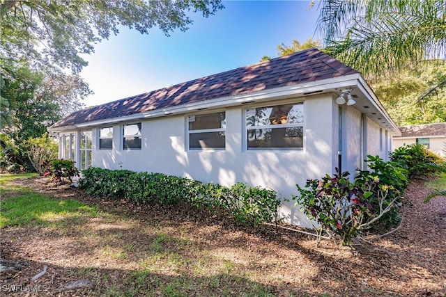 217 Yorkshire Ct Unit 2, Naples, FL 34112 - view of home's exterior featuring stucco siding and a shingled roof