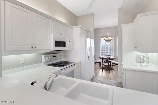 401 Bayfront Pl Unit 3502, Naples, FL 34102 - kitchen with white appliances, white cabinetry, light countertops, and decorative light fixtures