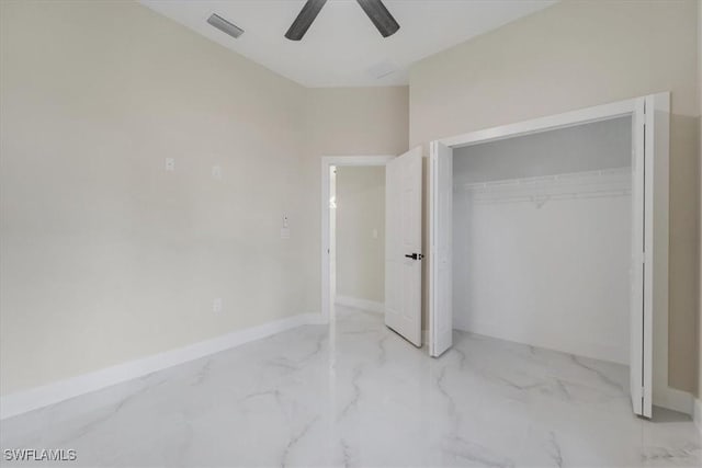 915 Anthony St E, Lehigh Acres, FL 33974 - unfurnished bedroom featuring a closet, marble finish floors, and a ceiling fan
