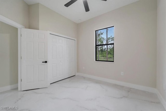915 Anthony St E, Lehigh Acres, FL 33974 - unfurnished bedroom with marble look tile flooring, a closet, and a ceiling fan