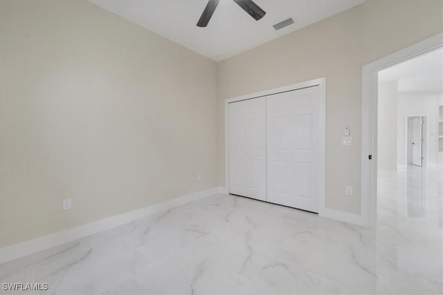 915 Anthony St E, Lehigh Acres, FL 33974 - unfurnished bedroom with marble finish flooring, a closet, and a ceiling fan