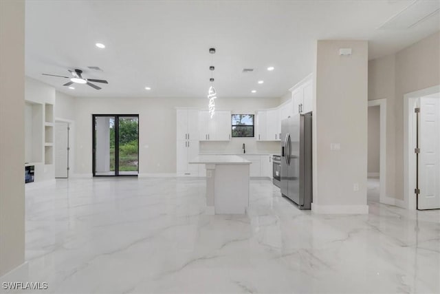 915 Anthony St E, Lehigh Acres, FL 33974 - kitchen featuring stainless steel fridge with ice dispenser, open floor plan, a kitchen island, white cabinets, and light marble finish flooring