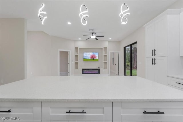 915 Anthony St E, Lehigh Acres, FL 33974 - kitchen with white cabinetry, recessed lighting, open floor plan, ceiling fan, and light stone countertops
