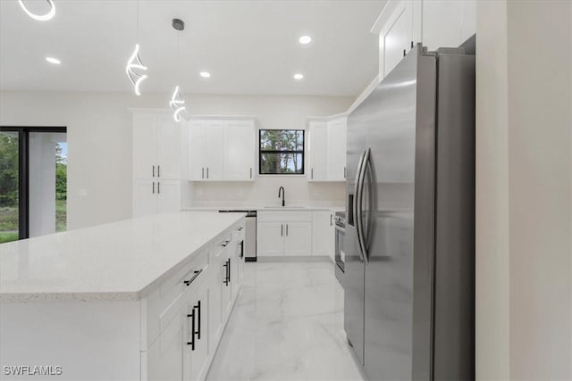 915 Anthony St E, Lehigh Acres, FL 33974 - kitchen with stainless steel appliances, light marble finish floors, recessed lighting, white cabinets, and hanging light fixtures