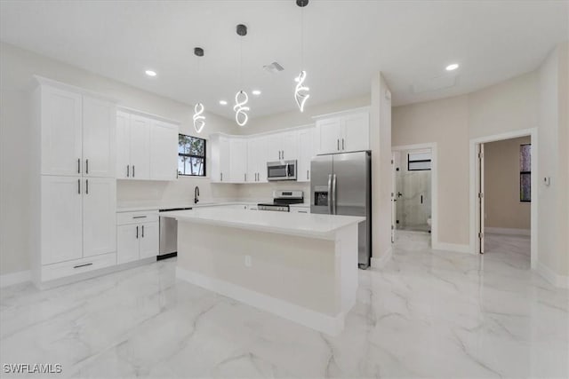 915 Anthony St E, Lehigh Acres, FL 33974 - kitchen featuring appliances with stainless steel finishes, white cabinetry, recessed lighting, light marble finish floors, and a center island