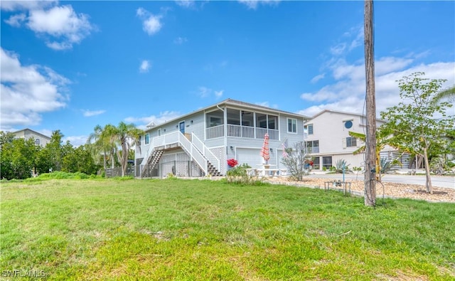 6008 Cypress Ln, Bonita Springs, FL 34134 - back of house with a sunroom, stairway, a yard, and a garage