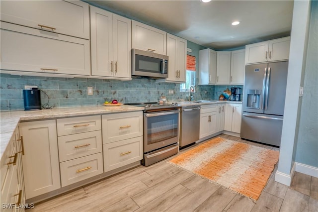 6008 Cypress Ln, Bonita Springs, FL 34134 - kitchen with appliances with stainless steel finishes, decorative backsplash, light wood-style flooring, recessed lighting, and light stone countertops