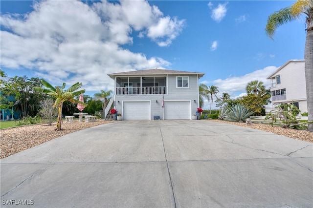 6008 Cypress Ln, Bonita Springs, FL 34134 - raised beach house with stairway, concrete driveway, and a garage