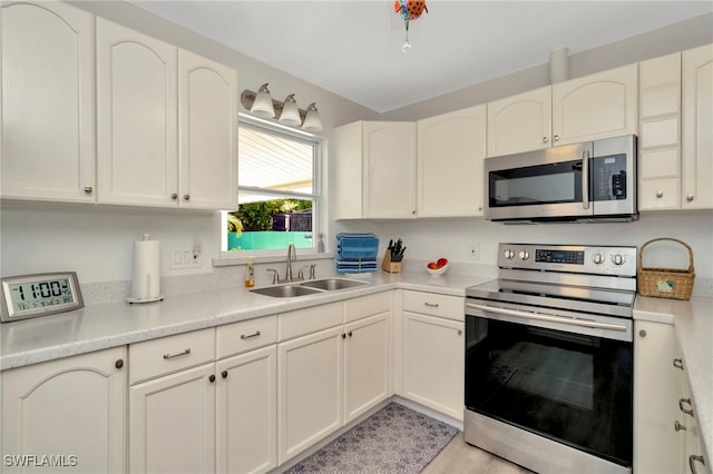 1308 Hull St S, Gulfport, FL 33707 - kitchen featuring appliances with stainless steel finishes, light countertops, and white cabinetry