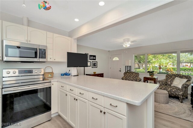 1308 Hull St S, Gulfport, FL 33707 - kitchen featuring appliances with stainless steel finishes, a peninsula, light countertops, light wood-style floors, and recessed lighting