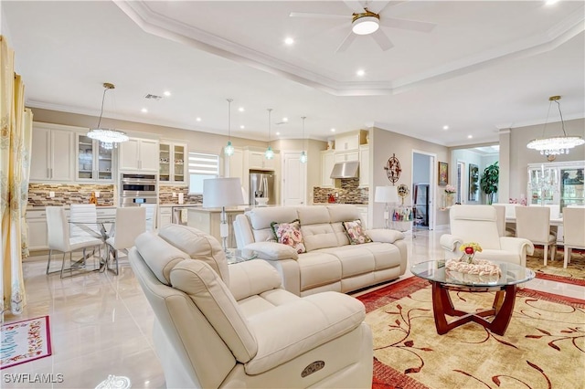 8142 Lucello Ter S, Naples, FL 34114 - living room featuring recessed lighting, a ceiling fan, a chandelier, ornamental molding, and a tray ceiling