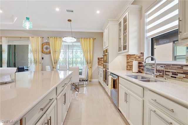 8142 Lucello Ter S, Naples, FL 34114 - kitchen featuring stainless steel dishwasher, tasteful backsplash, light countertops, white cabinetry, and hanging light fixtures