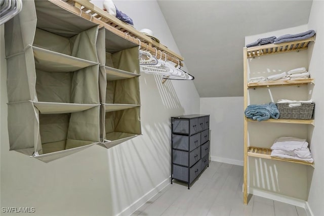 14712 Kingfisher Loop, Naples, FL 34120 - walk in closet featuring lofted ceiling and wood finished floors