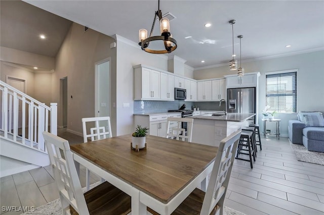 14712 Kingfisher Loop, Naples, FL 34120 - dining room with a chandelier, crown molding, stairs, recessed lighting, and light wood-type flooring