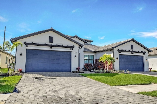 14712 Kingfisher Loop, Naples, FL 34120 - view of front facade with an attached garage, stucco siding, decorative driveway, and a front lawn