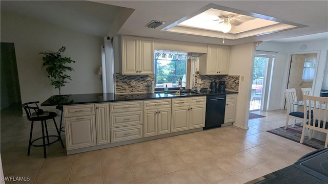 169 SE 21st St, Cape Coral, FL 33990 - kitchen featuring dishwasher, decorative backsplash, light tile patterned flooring, a raised ceiling, and dark countertops