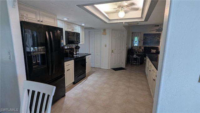 169 SE 21st St, Cape Coral, FL 33990 - kitchen featuring black appliances, dark countertops, white cabinetry, a tray ceiling, and a ceiling fan