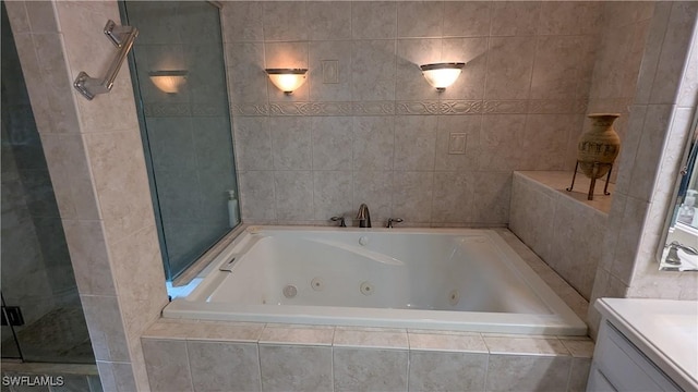 169 SE 21st St, Cape Coral, FL 33990 - bathroom with a jetted tub, vanity, a shower stall, and tile walls