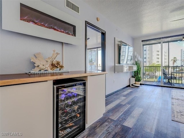 4431 Bay Beach Ln Unit 522, Fort Myers Beach, FL 33931 - indoor dry bar featuring beverage cooler, a textured ceiling, and wood finished floors