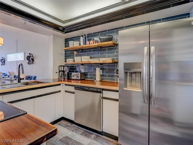 4431 Bay Beach Ln Unit 522, Fort Myers Beach, FL 33931 - kitchen with appliances with stainless steel finishes, white cabinetry, backsplash, wooden counters, and open shelves