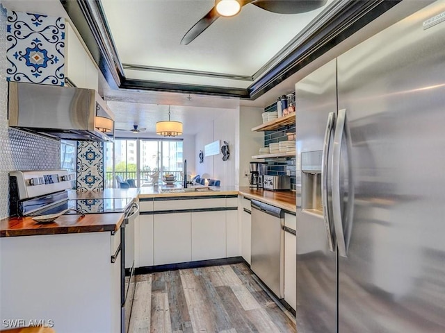 4431 Bay Beach Ln Unit 522, Fort Myers Beach, FL 33931 - kitchen with appliances with stainless steel finishes, wooden counters, wood finished floors, open shelves, and white cabinets