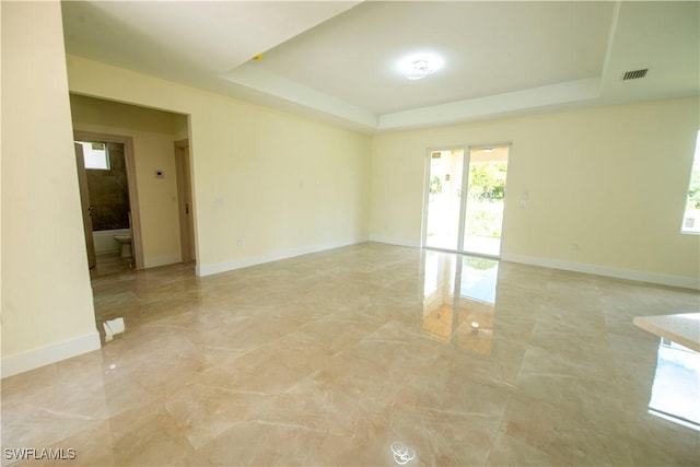 3407 E 5th St, Lehigh Acres, FL 33972 - spare room featuring light marble finish flooring and a tray ceiling