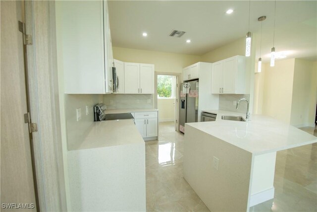 3407 E 5th St, Lehigh Acres, FL 33972 - kitchen with stainless steel appliances, a peninsula, recessed lighting, white cabinetry, and light countertops