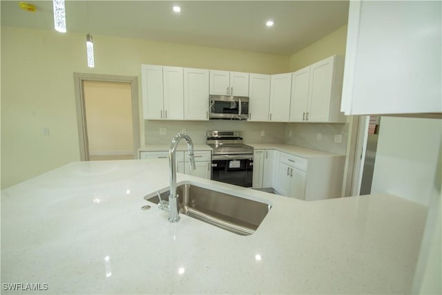 3407 E 5th St, Lehigh Acres, FL 33972 - kitchen with appliances with stainless steel finishes, decorative backsplash, white cabinetry, and recessed lighting