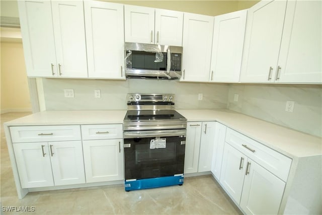 3407 E 5th St, Lehigh Acres, FL 33972 - kitchen with stainless steel appliances, light countertops, and white cabinetry