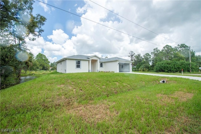 3407 E 5th St, Lehigh Acres, FL 33972 - view of property exterior featuring a lawn, driveway, and stucco siding