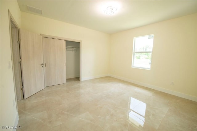 3407 E 5th St, Lehigh Acres, FL 33972 - unfurnished bedroom featuring light marble finish floors and a closet