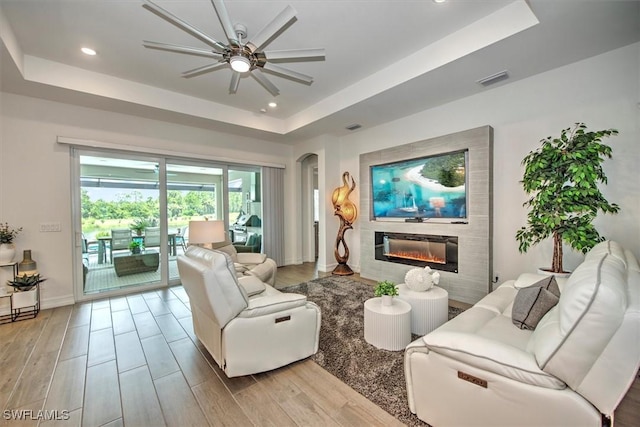 3649 Avenida Del Vera, North Fort Myers, FL 33917 - living area with a raised ceiling, ceiling fan, a glass covered fireplace, light wood-type flooring, and recessed lighting