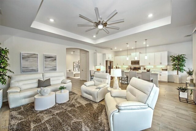 3649 Avenida Del Vera, North Fort Myers, FL 33917 - living area with ceiling fan, a raised ceiling, arched walkways, light wood-style floors, and recessed lighting