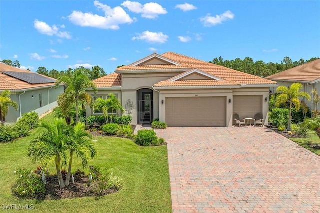 3649 Avenida Del Vera, North Fort Myers, FL 33917 - mediterranean / spanish-style house with an attached garage, a front yard, a tile roof, and decorative driveway