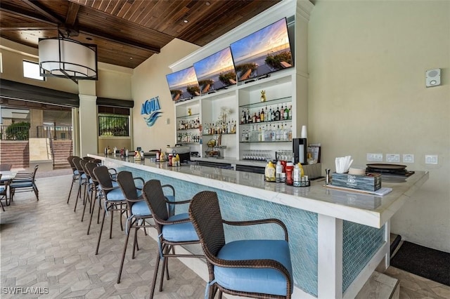 580 El Camino Real Unit 3606, Naples, FL 34119 - indoor dry bar with wooden ceiling, decorative light fixtures, stone finish flooring, and high vaulted ceiling