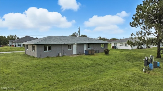 125/127 Gordon Ave S, Lehigh Acres, FL 33973 - back of house with a lawn and roof with shingles