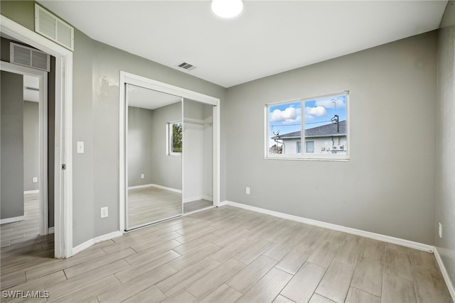 125/127 Gordon Ave S, Lehigh Acres, FL 33973 - unfurnished bedroom featuring wood tiled floors and a closet