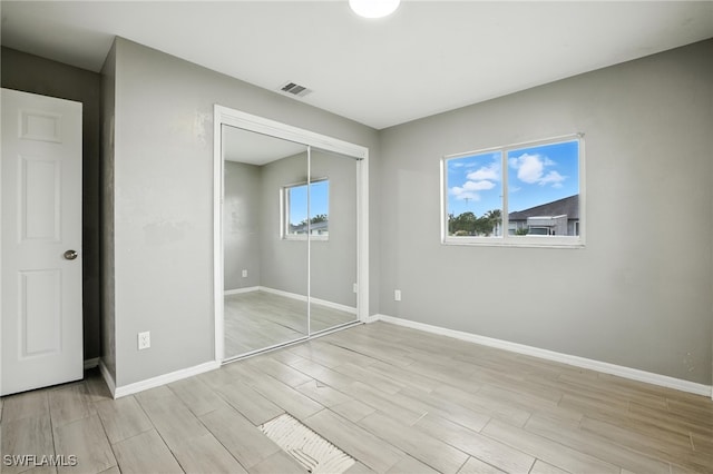 125/127 Gordon Ave S, Lehigh Acres, FL 33973 - unfurnished bedroom featuring light wood-style flooring and a closet